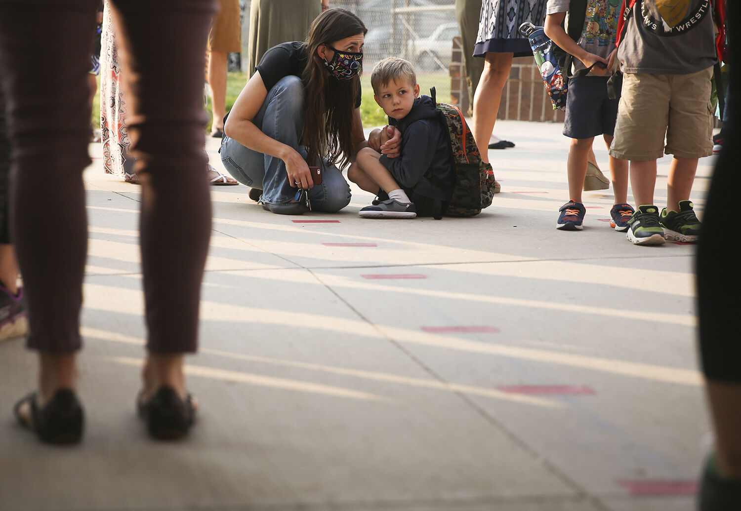 Jessica Zimmerschied sits with her son Bridger Silvan, 6, as they wait in his class line